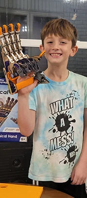 Boy wearing the Mechanical Hand he built